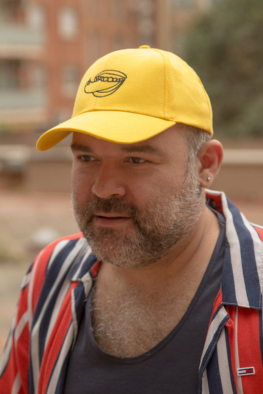 GORRA AMARILLA EN LA PUNTA DE LA LENGUA